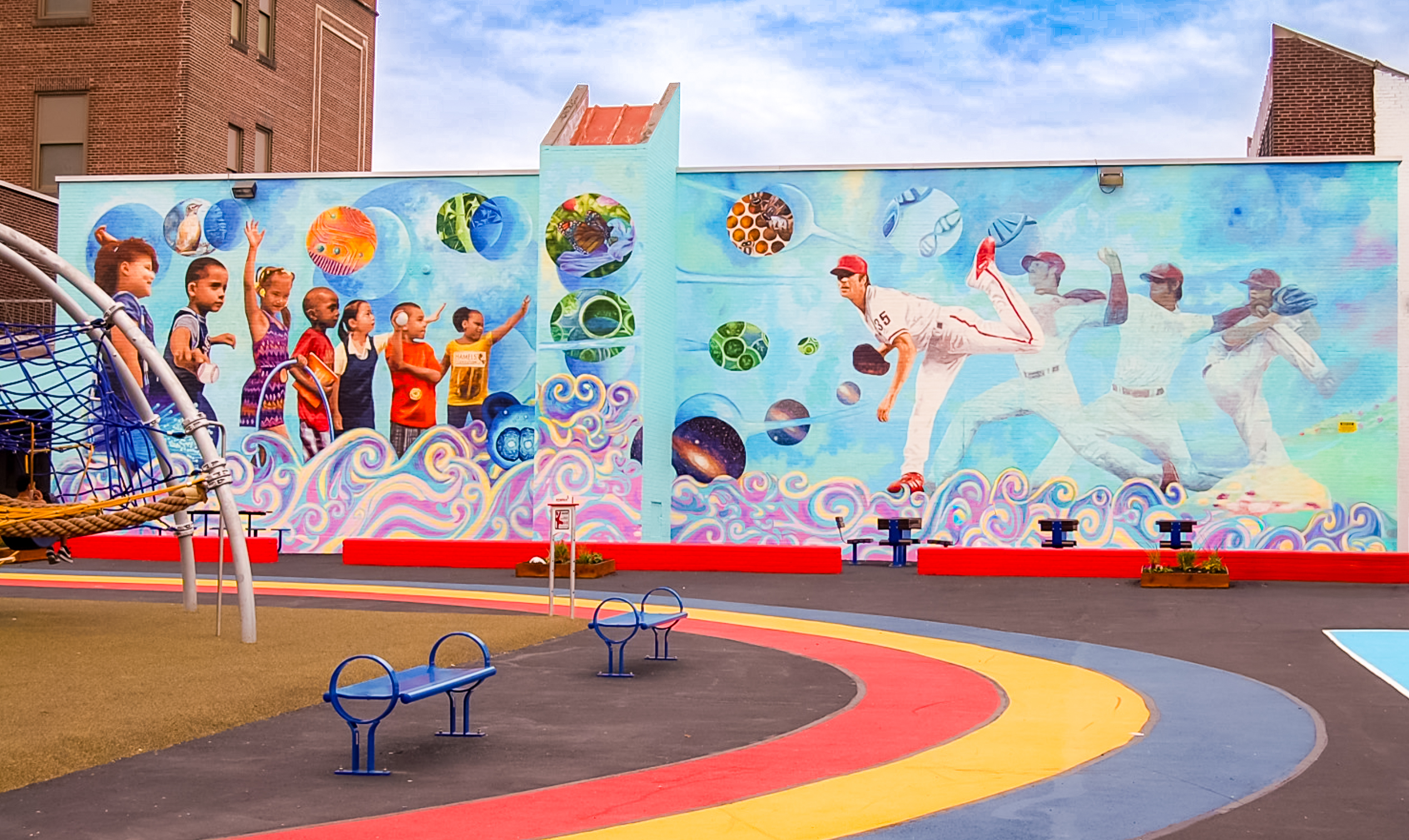 Bayard Taylor School Playground Bayard Taylor School playground featuring colorful play equipment, a running track and a large mural of children, nature and baseball players.